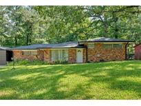 Charming brick ranch home with a lush green lawn and mature trees at 6600 N Beulah Rd, Lithia Springs, GA 30122