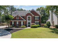 Charming brick two-story home with well-manicured lawn and lush landscaping at 161 Forestview Dr, Suwanee, GA 30024