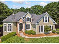 Charming home featuring manicured landscaping, stone accents, arched windows, and black shutters at 3845 Overlake Dr, Cumming, GA 30041