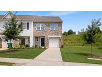 Charming brick and siding townhouse with a well-manicured lawn and attached garage at 161 Swindon Dr, Mcdonough, GA 30253