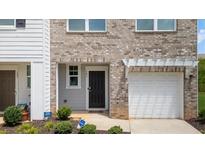 Charming townhouse featuring a black front door, attached garage and manicured front yard at 161 Swindon Dr, Mcdonough, GA 30253