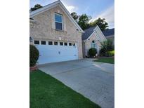 Charming brick home featuring a two-car garage, a well-maintained lawn, and an inviting driveway at 979 Simonton Glen Dr, Lawrenceville, GA 30045