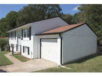 Charming two-story home featuring white painted brick, siding, a two-car garage, and a well-manicured lawn at 1417 Pineglen Dr, Riverdale, GA 30296