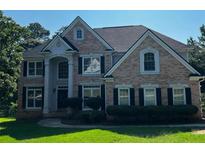 Charming two-story brick home with black shutters and well-maintained landscaping, perfect for curb appeal at 2550 Lynshire Ln, Snellville, GA 30078