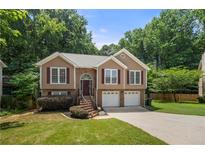 Charming split-level home with brick accents, attached two-car garage, and a well-manicured lawn at 2775 Harper Ferry Dr, Lawrenceville, GA 30044