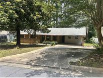 Cozy single-story brick house with a long driveway and mature trees at 4595 Sahara Sw Dr, Atlanta, GA 30331