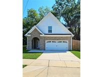 Charming brick two-story home with a white garage door and arched entryway at 1081 Hardin Street Sw St, Conyers, GA 30012