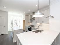 Bright kitchen features quartz countertops, stainless appliances, and a kitchen island at 352 Olmstead Way # 28, Alpharetta, GA 30022