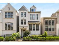 Charming, modern, three-story white brick home with black-trimmed windows, black metal fence, and verdant landscaping at 506 Broadview Ne Pl, Atlanta, GA 30324