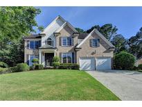 Charming brick two-story home with manicured lawn and attached two-car garage in a desirable neighborhood at 1723 Woodbow Path, Dacula, GA 30019