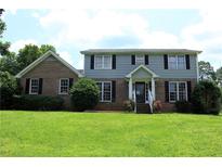 Charming two-story home featuring a well-manicured lawn and inviting front porch with beautiful shrubbery at 4814 Delgado Dr Sw, Lilburn, GA 30047