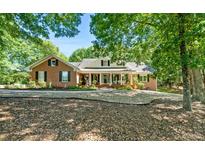 Charming brick home with a cozy front porch and beautiful landscaping, perfect for relaxing outdoors at 401 Riverwalk, Mcdonough, GA 30252