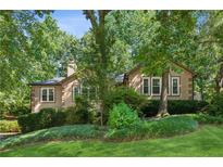 Charming home with lush landscaping and mature trees offering shade and privacy at 120 Timbervalley Ln, Lawrenceville, GA 30043