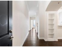 Bright hallway boasts hardwood floors and built-in shelving, leading to an airy living space at 3445 Stratford Ne Rd # 3403, Atlanta, GA 30326