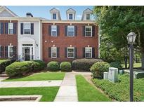 Charming brick townhome with well-manicured lawn and neatly trimmed bushes, providing curb appeal at 350 Eagle Tiff Dr, Sugar Hill, GA 30518