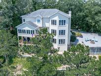Stunning three-story home with a spacious deck, ample windows, and a charming outdoor entertainment area with fire pit at 7560 Island Mill Rd, Acworth, GA 30102