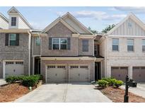 Charming brick townhome with a two-car garage and meticulously manicured landscaping at 1982 Brightleaf Way, Marietta, GA 30060