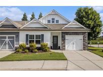 Charming townhome featuring stone accents, a well-manicured lawn, and a welcoming front entrance at 111 Point View Dr, Canton, GA 30114