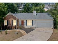 Charming one-story home with brick and vinyl siding, a well-manicured lawn, and a concrete driveway at 3997 Paloverde Nw Dr, Kennesaw, GA 30144