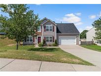 Charming two-story home featuring a well-manicured lawn, gray siding, and a two-car garage on a sunny day at 1644 Royal Ives Dr, Lawrenceville, GA 30045
