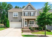 Charming two-story home with gray siding, white trim, front porch, attached two-car garage, and nicely landscaped front yard at 310 Braeden Way, Alpharetta, GA 30009