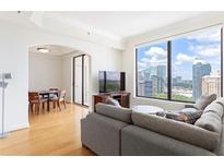 Bright living room features hardwood floors, large windows showcasing the city view, and a dining area at 3445 Stratford Ne Rd # 2409, Atlanta, GA 30326