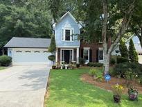 Charming home featuring a two-car garage, manicured lawn, and a mix of brick and siding facade at 3545 Manchester Dr, Lawrenceville, GA 30044