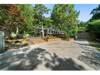 Charming home with a large front yard, wooden retaining wall, and an abundance of mature trees at 528 Pumpkinvine Rd, Acworth, GA 30101