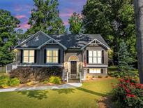 Charming two-story home with well-maintained lawn, colorful flowerbeds, and mature trees at 70 Maplewood Ln, Acworth, GA 30101