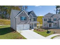 Charming two-story home with a gray brick facade, two-car garage, and neatly landscaped front yard at 1821 Lacebark Elm Way, Lawrenceville, GA 30045