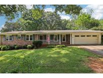Charming brick ranch home with a well-maintained lawn and an attached garage at 5623 Crestwood Dr, Stone Mountain, GA 30087