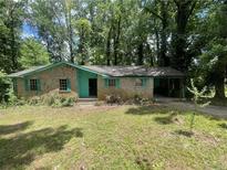 Charming brick home with a covered carport and lush, mature trees surrounding the property at 2890 Bianca Ct, Decatur, GA 30034