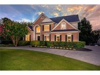 Charming two-story brick home with manicured lawn, elegant landscaping, and a circular driveway at 801 Windsor Rdg, Canton, GA 30115