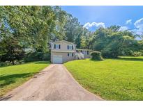 Charming two-story home with a well-manicured front lawn and a paved driveway leading to an attached garage at 1658 Pine Glen Cir, Decatur, GA 30035