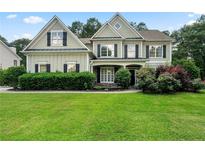 Charming two-story home with manicured lawn and lush landscaping at 1691 Holcomb Lake Rd, Marietta, GA 30062