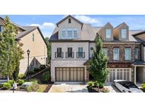 Beautiful townhome with brick and stucco exterior, two-car garage, and well-manicured landscaping at 117 Via Roma, Woodstock, GA 30188