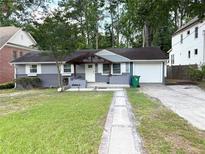 Charming single-story home with gray siding, a pergola-covered porch, and an attached one-car garage at 1872 Canmont Ne Dr, Brookhaven, GA 30319