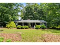 Charming single-story home featuring a well-maintained front yard with mature landscaping at 220 Gamble Dr, Carrollton, GA 30116