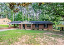 Charming brick ranch home with a cozy carport and traditional curb appeal surrounded by mature trees at 4748 Carson Sw Pass, Atlanta, GA 30331
