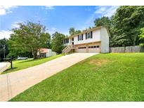 Charming two-story home features a long driveway, two-car garage, and a welcoming front yard at 2706 Del Ridge Dr, Douglasville, GA 30135