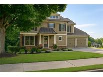 Charming two-story home with a well-manicured lawn and a two-car garage at 730 Midway Ave, Canton, GA 30114