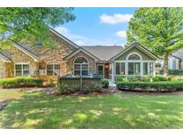 Charming backyard features stone and siding exterior, mature landscaping, and a cozy patio area at 5228 Stone Village Circle Northwest #14 Nw Cir # 14, Kennesaw, GA 30152