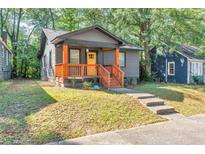 Charming home with a covered front porch, gray siding and a bright yellow front door at 1336 Mcclelland Ave, Atlanta, GA 30344