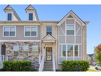 Charming townhome featuring a beautifully designed brick and siding exterior with a welcoming entrance and manicured landscaping at 5534 Radford Loop, Fairburn, GA 30213