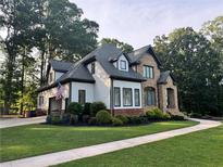Charming two-story home featuring a well-manicured lawn, stone accents, and an inviting front entrance at 6685 Driskell Rd, Cumming, GA 30041