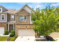 Two-story brick home with a front-facing garage, mature landscaping, and a well-manicured lawn at 3541 Ashcroft Se Dr, Smyrna, GA 30080