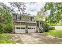 Charming two-story home with a stone facade, a two-car garage, and a well-manicured lawn at 4411 Westerling Ct, Powder Springs, GA 30127