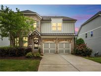 Charming brick and siding two-story home with a two-car garage and beautiful landscaping at 935 Grove Valley Drive Dr, Cumming, GA 30041