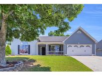 Charming home with a large, manicured front yard and a welcoming porch at 499 Running Doe Ct, Suwanee, GA 30024