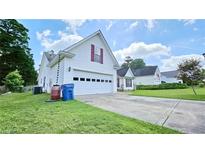 Charming two-story home featuring a white garage door and well-manicured lawn and colorful curb appeal at 2233 Hansford Pass, Buford, GA 30519